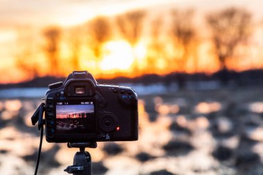 Kamera bir tripodun üzerinde manzara fotoğrafı çeker.
