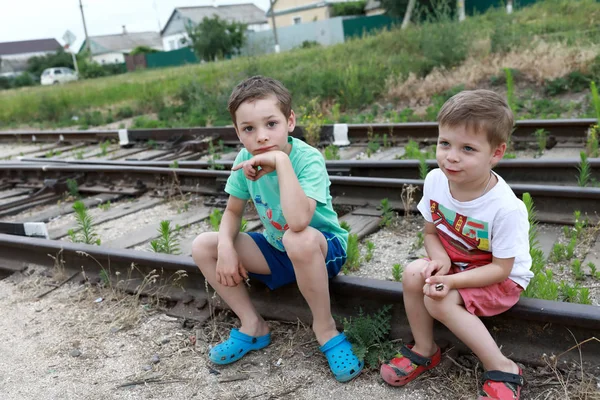 夏天坐在铁轨上的孩子们 — 图库照片