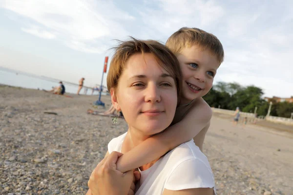儿子拥抱他的母亲在海滩上 — 图库照片