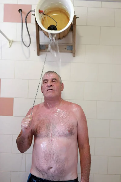 Oudere Man Gieten Emmer Water Zichzelf Sauna — Stockfoto