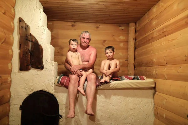 祖父与他的孙子坐在俄罗斯炉子在桑拿浴 — 图库照片