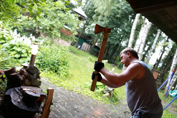 Adam kesme ahşap günlükleri ile arka bahçede balta