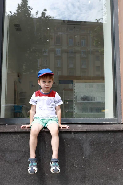 Kind Sitzt Auf Fensterbank Von Straßenseite — Stockfoto