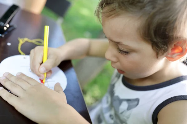 Мальчик Рисует Бумажный Круг Столом — стоковое фото