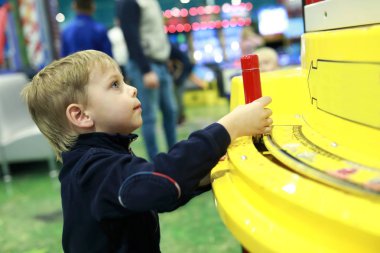 Arcade oyunu eğlence parkında oynayan çocuk