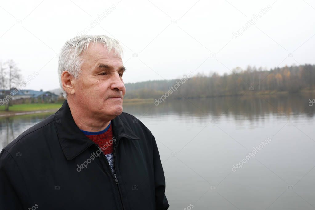 Senior man posing on Zaslavskoe Reservoir background