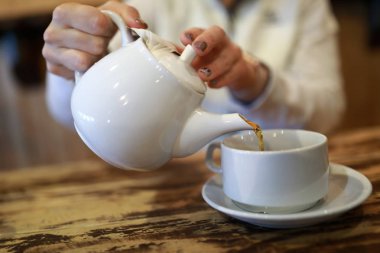 Bir kafede siyah çay dökülen kişi