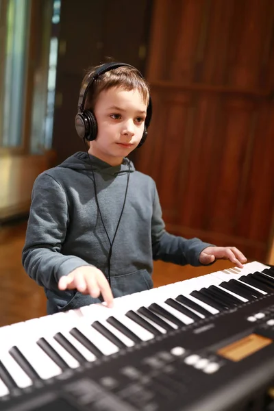 Kind Mit Kopfhörern Spielt Musikunterricht Auf Einem Synthesizer — Stockfoto