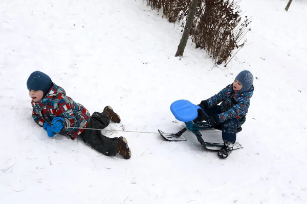 Kid Puxa Scooter Neve Com Seu Irmão Colina — Fotografia de Stock