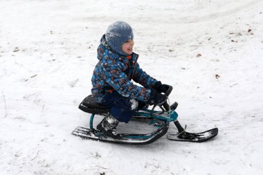 Kar scooter bir Tepesi'nden slaytlarda çocuk