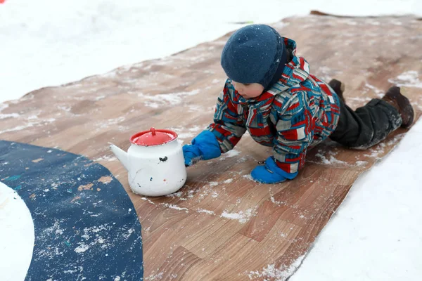 Ребенок Играет Кёрлинг Старыми Чайниками Зимой — стоковое фото