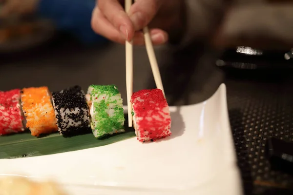 Člověk Bere Uramaki Sushi Roll Restauraci — Stock fotografie