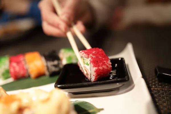 Person takes Uramaki Sushi in a restaurant