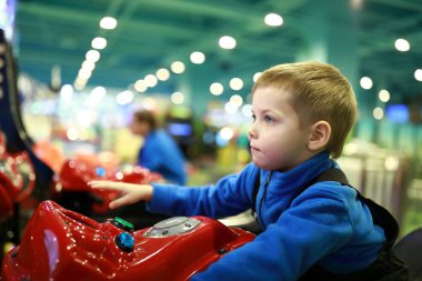Motosiklet simülatörü eğlence parkında oynayan çocuk