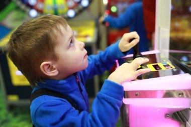 Arcade oyunu eğlence parkında oynayan çocuk