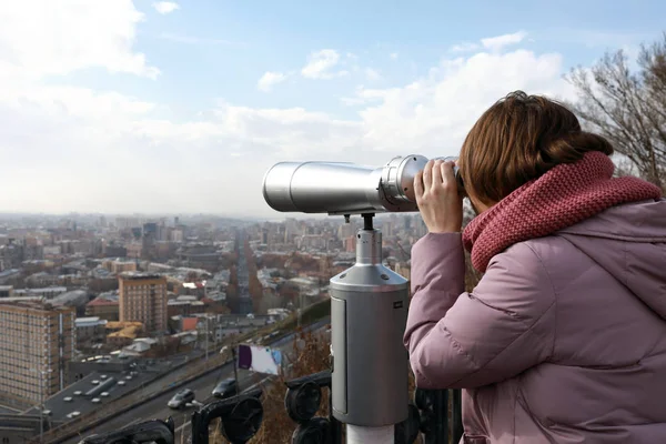通过固定式双筒望远镜在埃里温看的妇女 — 图库照片