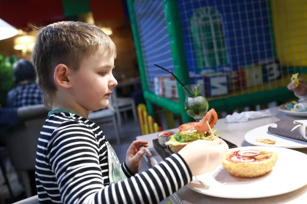 Niño comiendo hamburguesa — Foto de Stock