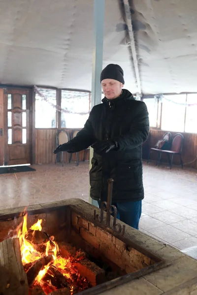 Mann wärmt Hände am Feuer — Stockfoto