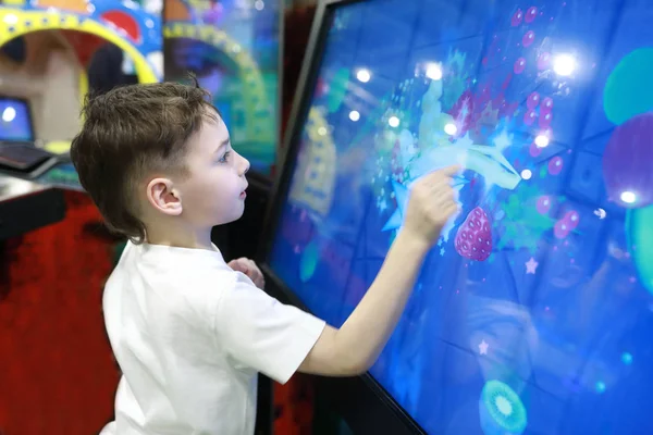 Niño jugando juego en la pantalla táctil grande — Foto de Stock