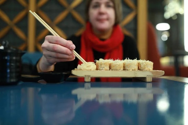 Mujer toma sushi con palillos —  Fotos de Stock