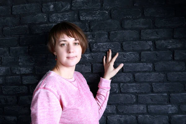 Woman on black brick wall background — Stock Photo, Image
