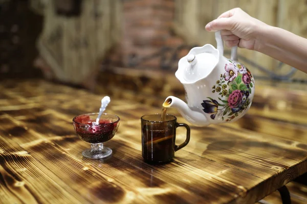 Person pouring tea from teapot — Stock Photo, Image