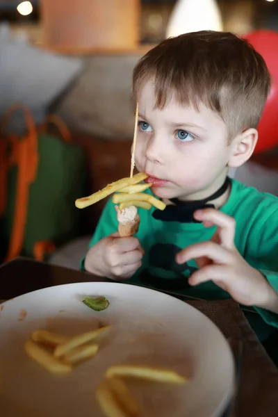 Pojken äta pommes frites — Stockfoto