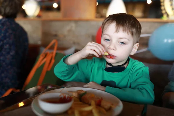 Niño comiendo papas fritas — Foto de Stock