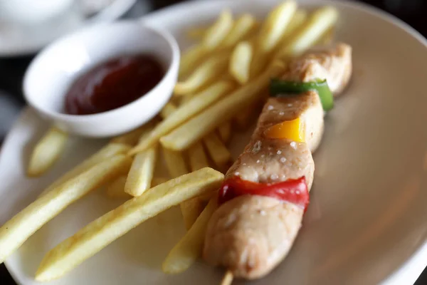 Kebab on skewer with french fries — Stock Photo, Image