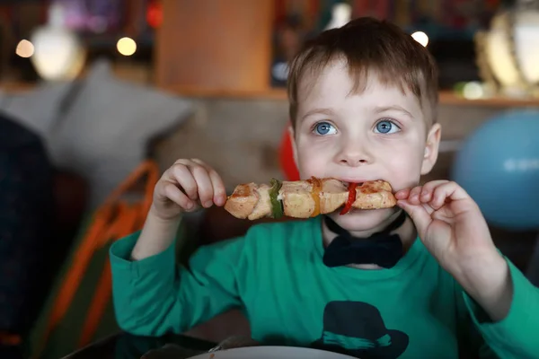 Niño comiendo kebab en pincho — Foto de Stock
