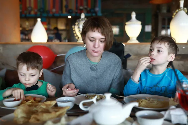 Mutter mit Söhnen essen — Stockfoto