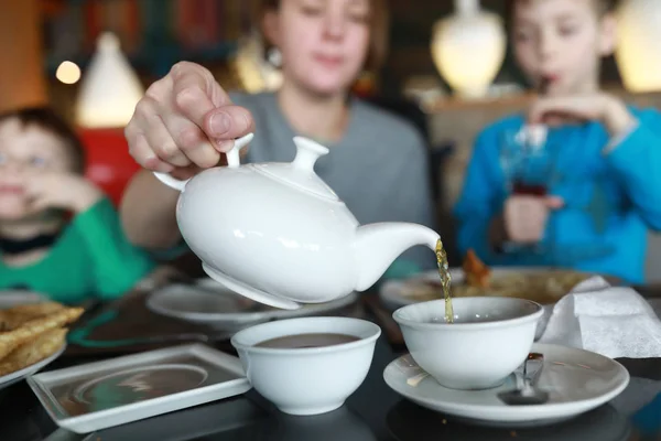 Woman pours black tea — Stock Photo, Image