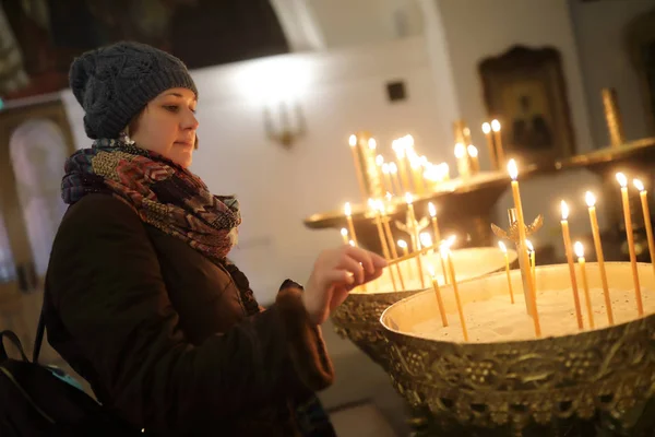 Vrouw met kaarsen in de kerk — Stockfoto