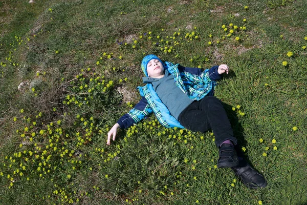 Menino deitado de costas no prado — Fotografia de Stock