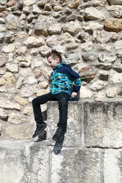 Мальчик на фоне крепостной стены — стоковое фото