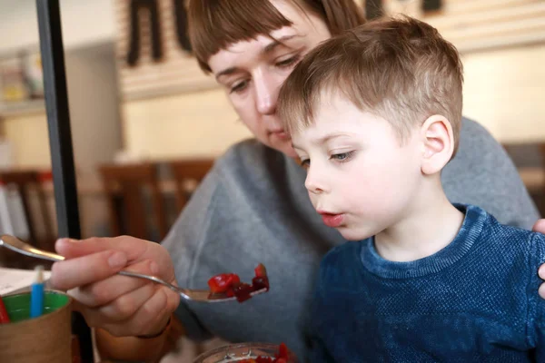 Moeder voedt zoon met salade van rode biet — Stockfoto