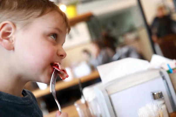 Ребенок ест вишневые пельмени — стоковое фото
