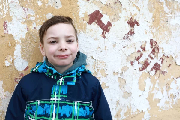 Jongen op oude muur achtergrond — Stockfoto