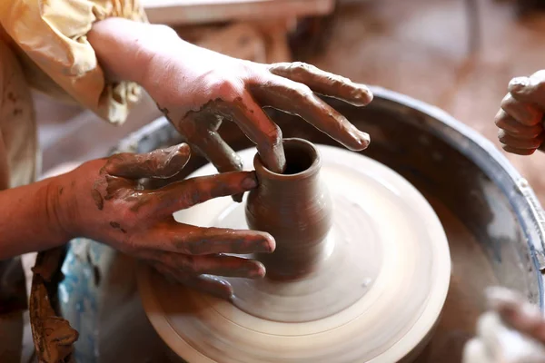 Person makes clay pot on potters wheel — Stock Photo, Image