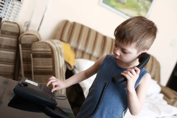 Niño con teléfono de escritorio —  Fotos de Stock