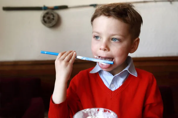 Barn slickar halm från milkshake — Stockfoto