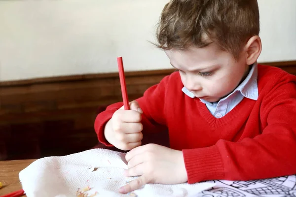 Child sharpens pencil — Stock Photo, Image