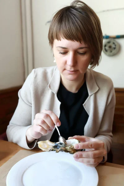 Woman eating oysters — Stock Photo, Image