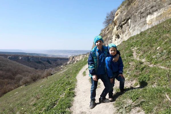 Testvér pózol a Chufut-Kale erőd háttérben — Stock Fotó