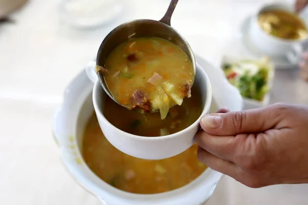 Persona vertiendo sopa de guisantes — Foto de Stock