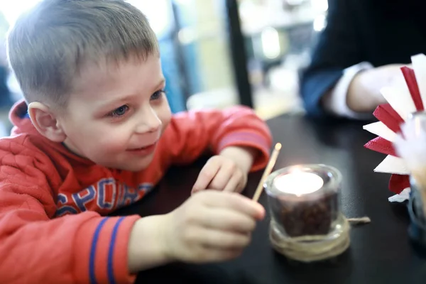 Boy sets fire to candle — Stock Photo, Image