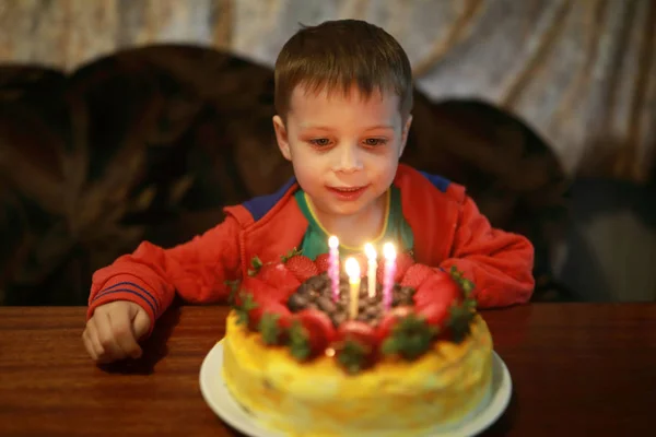 Kind blaast kaarsen uit — Stockfoto