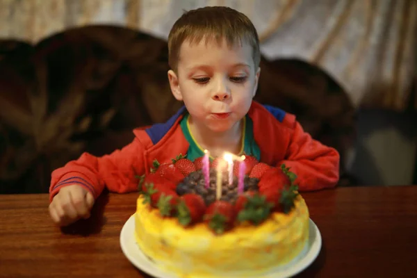 Kid blows out candles — Stock Photo, Image