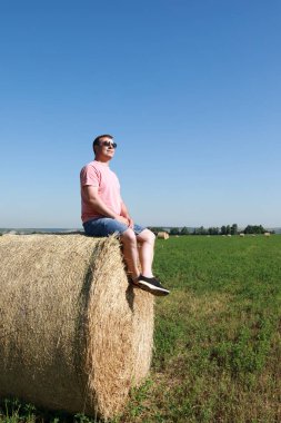 Saman balyası üzerinde dinlenen adam