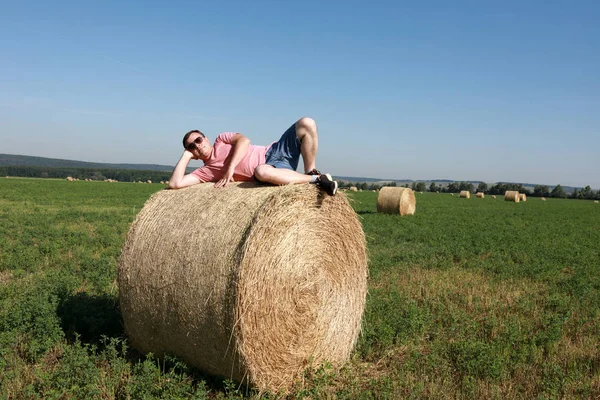 Person lying on bale of straw — Stock Photo, Image